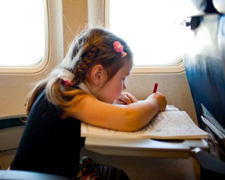 little girl coloring on airplane