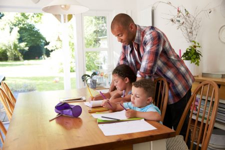 father helping children with homework